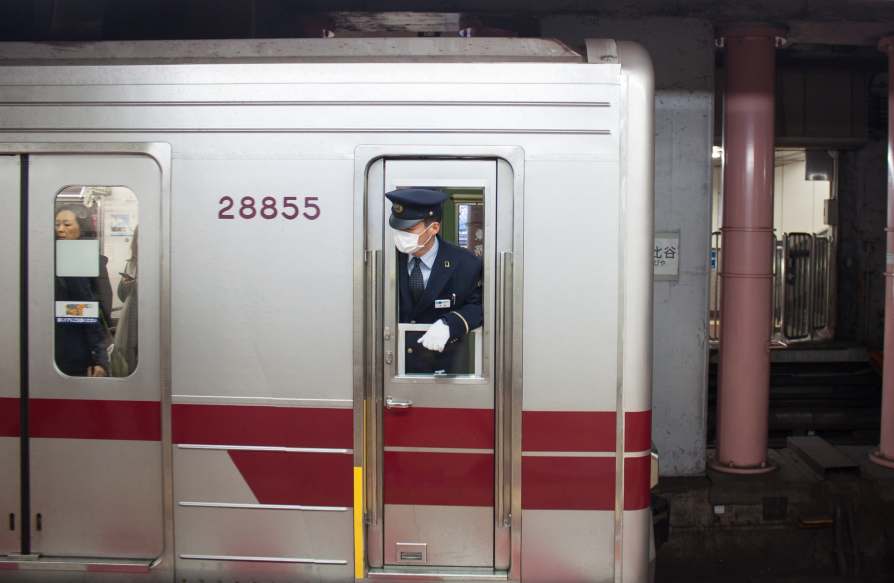 Japanese train worker using a face mask during the COVID pandemic